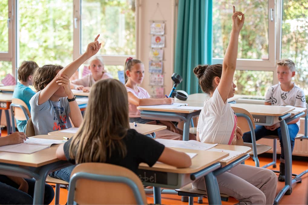 Schulklasse mit meldenden Kindern – Bildungsumfeld als Anwendungsbereich der Asset Verwaltungssoftware