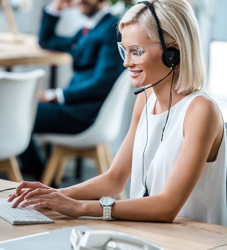 Frau mit Headset arbeitet am Laptop – digitale Unterstützung und Verwaltung von Anfragen im Asset Management